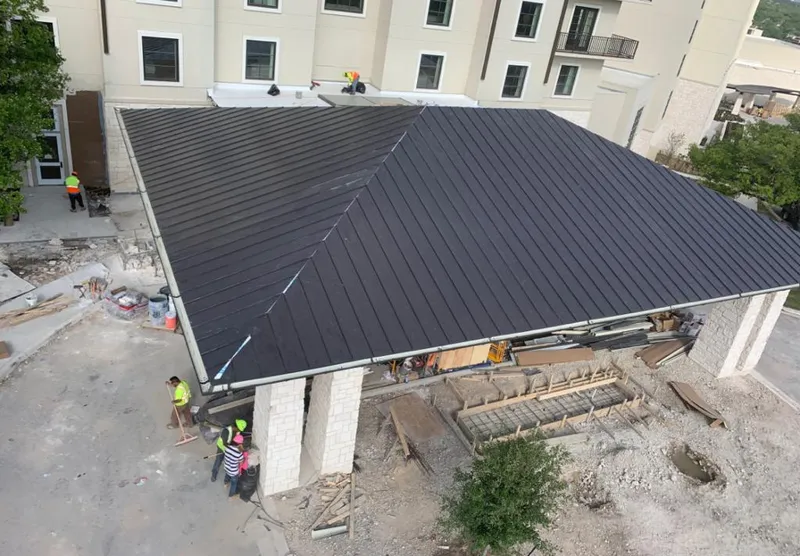 Metal roofing installation team working on a commercial building in Antigo